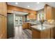 Updated kitchen featuring wood cabinets, stone backsplash, and stainless steel appliances at 11724 Little Turtle Ln, Conifer, CO 80433