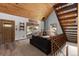 Inviting living room featuring a wood ceiling, fireplace, and large windows with a staircase at 11724 Little Turtle Ln, Conifer, CO 80433