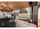 Spacious living room featuring wood ceilings, a fireplace, and views of nature through large windows at 11724 Little Turtle Ln, Conifer, CO 80433