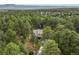 Aerial view of the home nestled among dense green trees with a long driveway leading up to the house at 10 Long Bow Cir, Monument, CO 80132