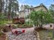 Picture of the backyard of this two-story home with a stone patio, outdoor fireplace, mature trees and landscaping at 10 Long Bow Cir, Monument, CO 80132
