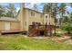Exterior of this multi-story home with a wooden deck and stairs surrounded by mature trees and lawn at 10 Long Bow Cir, Monument, CO 80132