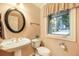 Bathroom features a pedestal sink, with an oval mirror and a view of the neighborhood at 10 Long Bow Cir, Monument, CO 80132