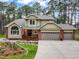 Charming two-story home with brick accents, an inviting front porch, a three-car garage, and landscaped front yard at 10 Long Bow Cir, Monument, CO 80132