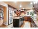Spacious kitchen with dark wood cabinetry, granite countertops, stainless steel appliances, and a functional center island at 10 Long Bow Cir, Monument, CO 80132