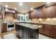 Elegant kitchen featuring dark wood cabinets, granite countertops, stainless steel appliances, and a center island at 10 Long Bow Cir, Monument, CO 80132