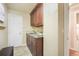 Laundry room with tile flooring, sink, wooden cabinetry and marble countertops at 10 Long Bow Cir, Monument, CO 80132