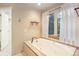 Bright main bathroom with a jacuzzi tub, natural light, and views of the outdoors at 10 Long Bow Cir, Monument, CO 80132