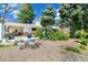 Landscaped backyard with stone, a white outdoor table and seating surrounded by mature trees at 7970 S Cook Way, Centennial, CO 80122