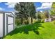 Well-maintained backyard with a shed, lush green lawn, and decorative landscaping at 7970 S Cook Way, Centennial, CO 80122