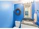 Small half bath with blue painted walls and a decorative mirror at 7970 S Cook Way, Centennial, CO 80122