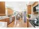Open kitchen with wood cabinets, stainless steel appliances, solid surface counters, and wood floors at 7970 S Cook Way, Centennial, CO 80122