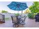 Charming back patio with a large umbrella and a dining set with four swivel chairs at 860 Bramblewood Dr, Castle Pines, CO 80108