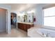 Bathroom featuring dual vanities and a soaking tub at 860 Bramblewood Dr, Castle Pines, CO 80108