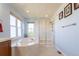 Bright bathroom with a shower, tub, and dual windows at 860 Bramblewood Dr, Castle Pines, CO 80108