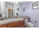 Well-lit powder bathroom showcasing vanity with a tile countertop and framed mirror at 860 Bramblewood Dr, Castle Pines, CO 80108