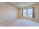 Bright bedroom featuring neutral walls, carpet, and natural light from windows with patterned curtains at 860 Bramblewood Dr, Castle Pines, CO 80108