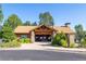 Community clubhouse featuring a stone facade, wooden beams, and landscaped surroundings at 860 Bramblewood Dr, Castle Pines, CO 80108