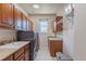 Laundry room with wooden cabinets, modern washer and dryer, utility sink, and a window for natural light at 860 Bramblewood Dr, Castle Pines, CO 80108