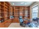 Spacious office featuring custom built-in wooden bookshelves and cabinets with a desk area overlooking the window at 860 Bramblewood Dr, Castle Pines, CO 80108