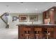 Basement bar area with dark wood cabinets, granite countertops, seating, and stairs leading upstairs at 395 N Franklin St, Denver, CO 80218
