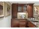 Bar area featuring wood cabinets, decorative backsplash, granite countertop, and a wine refrigerator at 395 N Franklin St, Denver, CO 80218
