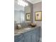 Bathroom vanity with blue cabinets, granite countertop, and decorative mirror featuring gray tile at 395 N Franklin St, Denver, CO 80218