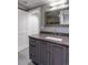 Modern bathroom with granite countertop, gray cabinets, large mirror with silver frame, and tiled floors at 395 N Franklin St, Denver, CO 80218