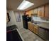 Efficient kitchen featuring stainless steel appliances, tile floors, and a bright skylight at 1755 S Pitkin St # B, Aurora, CO 80017