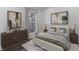 Staged bedroom featuring a comfortable bed, stylish dresser, and natural light from the window at 11973 E Kepner Dr, Aurora, CO 80012