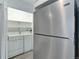 View of a pantry with stainless steel appliances, including a stainless steel refrigerator and a washing machine at 11973 E Kepner Dr, Aurora, CO 80012