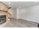 View of a living room, showcasing a beautiful stone fireplace with a wooden mantel and new gray floors at 11973 E Kepner Dr, Aurora, CO 80012