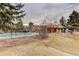 View of the community pool with a view of the community buildings surrounded by mature trees at 11973 E Kepner Dr, Aurora, CO 80012