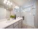 Bright bathroom with double vanity, quartz countertop, modern fixtures, and glass shower door at 13518 E 103Rd Pl, Commerce City, CO 80022