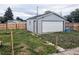 Exterior view of a detached one-car garage, featuring a white garage door and fenced yard at 6608 Hooker St, Denver, CO 80221