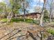 Natural backyard setting with mature trees and a brick home exterior at 12022 W Louisiana Ave, Lakewood, CO 80228