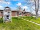 Spacious backyard features green grass, playhouse, brick exterior, and concrete patio at 12022 W Louisiana Ave, Lakewood, CO 80228