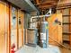 Unfinished basement featuring utilities: furnace, hot water heater, and exposed ductwork at 12022 W Louisiana Ave, Lakewood, CO 80228