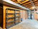 Unfinished basement with open ceiling, cement floor, and shelving for ample storage at 12022 W Louisiana Ave, Lakewood, CO 80228