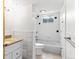 Bathroom featuring a granite-topped vanity, bathtub, white tiled walls, and updated fixtures at 12022 W Louisiana Ave, Lakewood, CO 80228