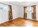 Cozy bedroom featuring hardwood floors, white walls, and natural light from two windows at 12022 W Louisiana Ave, Lakewood, CO 80228