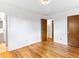 Bedroom featuring hardwood floors, white walls, with a view of an ensuite bathroom at 12022 W Louisiana Ave, Lakewood, CO 80228