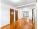 Spacious bedroom featuring hardwood floors, white walls, and a closet with mirrored doors at 12022 W Louisiana Ave, Lakewood, CO 80228