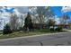 Street view of a charming brick home featuring a well-manicured front lawn with mature trees in a suburban neighborhood at 12022 W Louisiana Ave, Lakewood, CO 80228