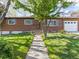 Charming brick home with lush green lawn, sidewalk, and inviting curb appeal at 12022 W Louisiana Ave, Lakewood, CO 80228