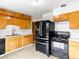 Functional kitchen with light wood cabinets, modern black appliances, and neutral countertops, offering efficiency and style at 12022 W Louisiana Ave, Lakewood, CO 80228