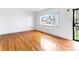 Open-concept living space featuring hardwood floors, large window, and views of the front yard, creating a warm and inviting atmosphere at 12022 W Louisiana Ave, Lakewood, CO 80228