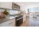 Modern kitchen with stainless steel appliances and granite countertops flows into a bright living area at 22093 E 38Th Pl, Aurora, CO 80019