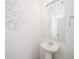 Contemporary powder room features a pedestal sink and modern light fixture at 22093 E 38Th Pl, Aurora, CO 80019