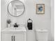 Bathroom features a round mirror over a white vanity with an adjacent toilet at 3230 Newport St, Denver, CO 80207